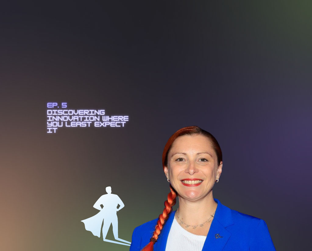 A woman named Nicola Bates is central to the image, with a silhouette of a caped person depicting a hero extending from her shoulder.