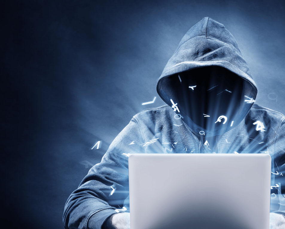 A man with hoodie sitting behind a laptop trying to run code to hack a security system